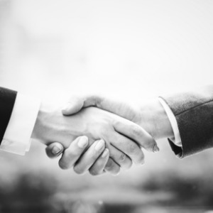 Why us? A handshake between two individuals to show mutual trust and commitment.