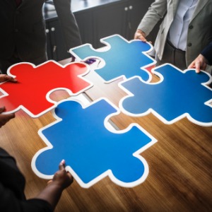 Individuals holding jigsaw pieces to represent the different funding and support a candidate can obtain.